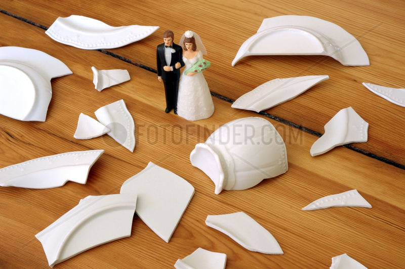 Figuren eines Hochzeitspaares stehen in einem Scherbenhaufen