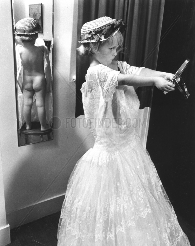 Maedchen in Kleid vor Spiegel