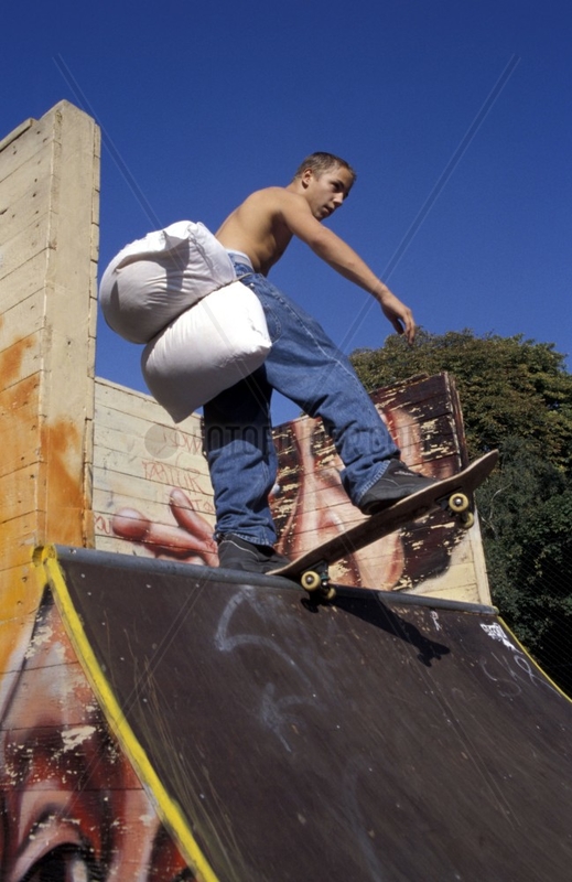 Skateboardfahrer mit Kissen am Po auf einer Rampe