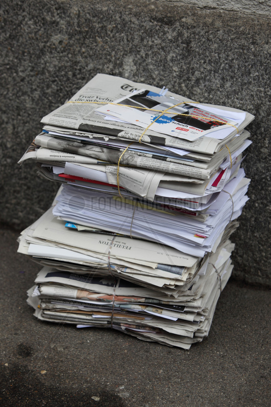 Zuerich,  Schweiz,  Zeitungsstapel lehnt an einer Hauswand