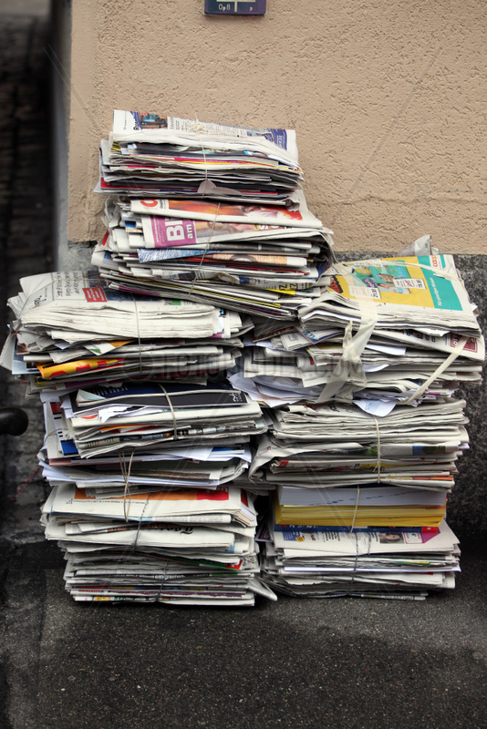 Zuerich,  Schweiz,  Zeitungsstapel lehnen an einer Hauswand