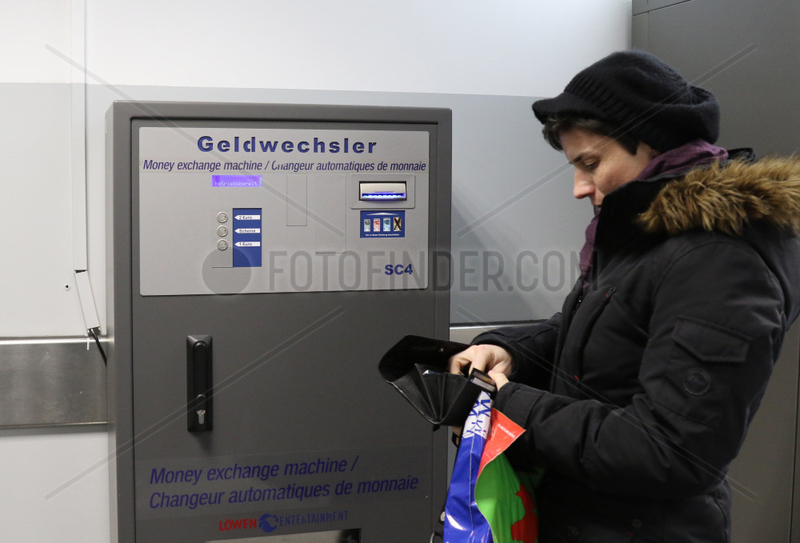 Berlin,  Deutschland,  Frau steht vor einem Geldwechselautomat