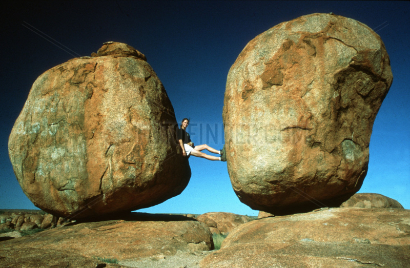 Frau zwischen zwei grossen runden Steinen