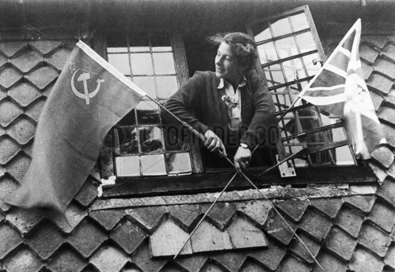 Woman with Union Jack and Soviet flags on VE Day,  8 May 1945.