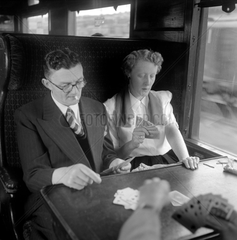 Passengers playing cards in a railway carriage,  1950.