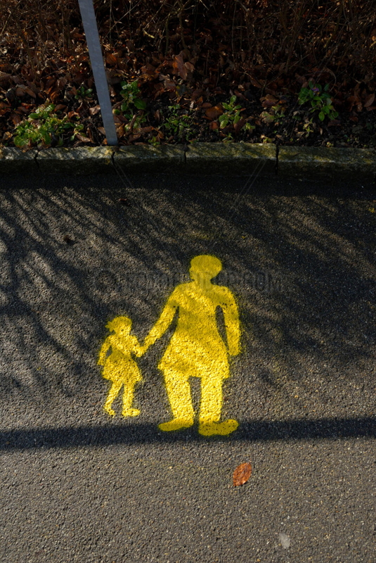 Gelbes Mutter und Kind Zeichen auf einer nassen Strasse in der Schweiz in Bern.