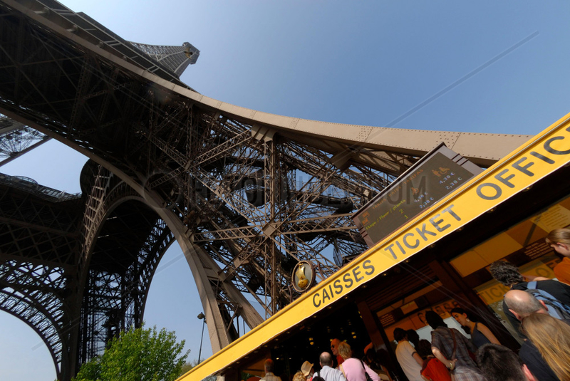 Touristen / Touristinnen an einer Kasse am Eingang zum Eiffelturm in Paris,  Frankreich.