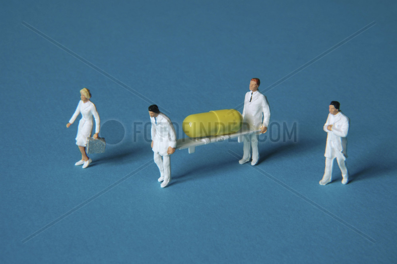 Figuren tragen Krankentrage mit Tablette