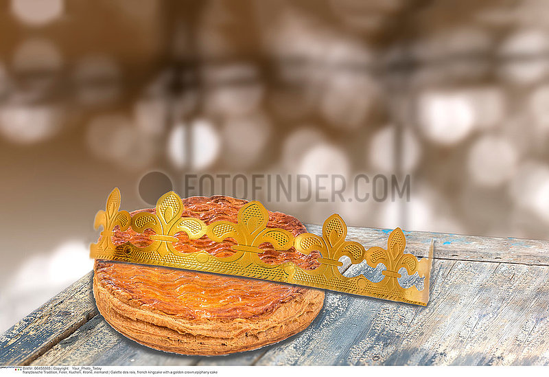 Galette des rois,  french kingcake with a golden crown,  on wooden table , epiphany cake against blury light