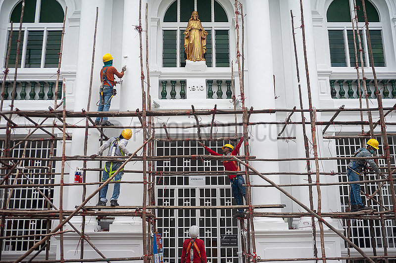 Singapur,  Republik Singapur,  Arbeiter bauen auf einer Baustelle ein hoelzernes Baugeruest ab