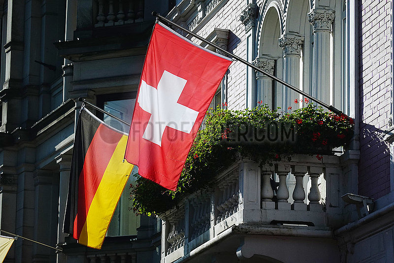Baden-Baden,  Deutschland,  Nationalfahne der Bundesrepublik Deutschland und der Schweiz stecken an einer Hausfassade