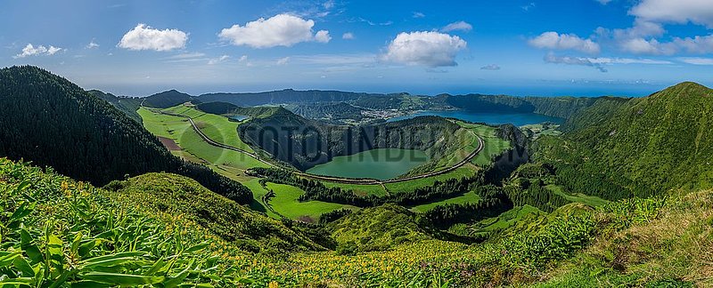 Portugal. Azores-Inseln,  Luftbild der Insel Sao Miguel (die touristischste des Archipels) mit seinen Sete Cidades,  einem vulkanischen Krater 12 km im Umfang,  der von seinem Gipfel an der Vista do Rei Belvedere entdeckt wird. Schlafen Sie unten die transparenten Gewässer seines grünen Sees und des blauen Seees. Der See wurde in der Mulde der Berge in der Mitte der Insel gebildet,  nach einem vulkanischen Ausbruch im 16. Jahrhundert. Ein beeindruckender Pfad geht um den Krater