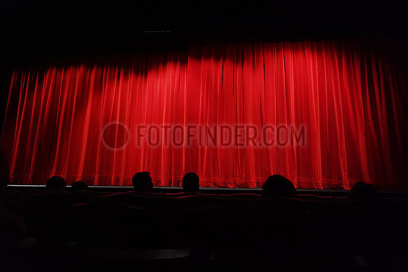 Berlin,  Deutschland,  Menschen sitzen in einem Theater vor einem geschlossenen Vorhang