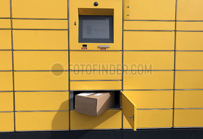Berlin,  Deutschland,  Paket in einem geoeffneten Fach einer Paketabholstation des Versanddienstleisters DHL