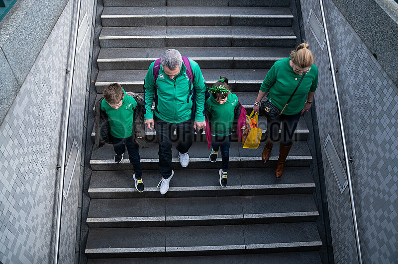 Berlin,  Deutschland,  Familie traegt gruene Kleidung zur Feier des St. Patrick's Day und geht Treppe zur U-Bahn runter