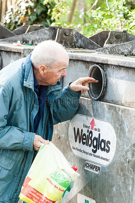 Rentner mit Leergut vor einem Flaschencontainer
