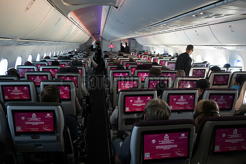 Doha,  Katar,  Passagiere in einer Flugzeugkabine erhalten ueber die Bordmonitore Informationen zu Zollbestimmungen bei der Einreise
