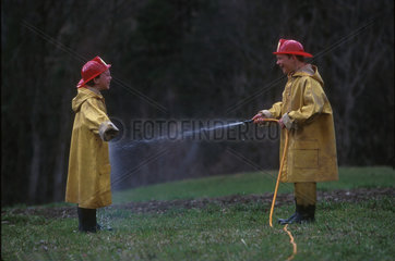 Zwei Kinder in Feuerwehranzuegen