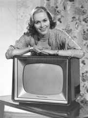 Frau posiert mit Fernseher