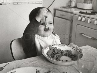 Kleinkind isst mit Loeffel