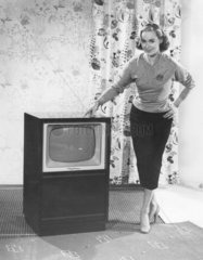 Frau posiert mit Fernseher