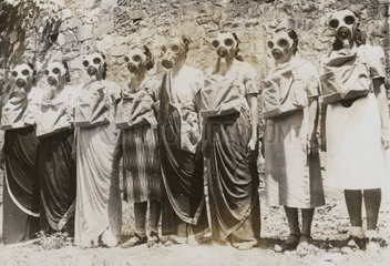 Frauen in einer Reihe mit Gasmasken