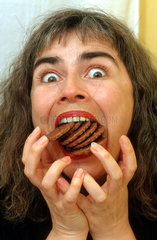 Frau isst viele Kekse