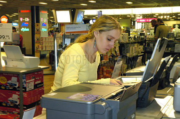 Junge Frau kauft Drucker bei Karstadt
