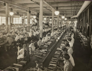 Maenner und Frauen bei Fabrikarbeit