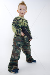 kleiner Junge in Tarnkleidung mit grosser Waffe