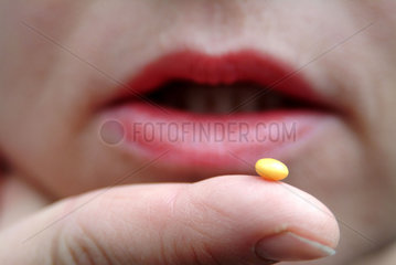 gelbe Pille auf der Fingerkuppe
