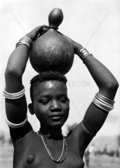afrikanische Frau traegt Gefaess auf dem Kopf
