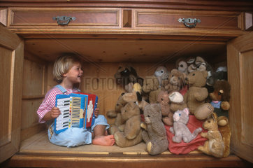 Kind mit Kuscheltieren im Schrank