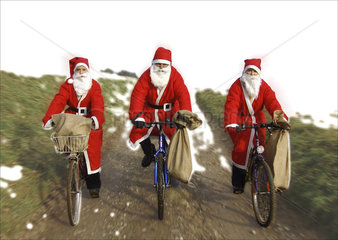 drei Weihnachtsmaenner auf Fahrraedern