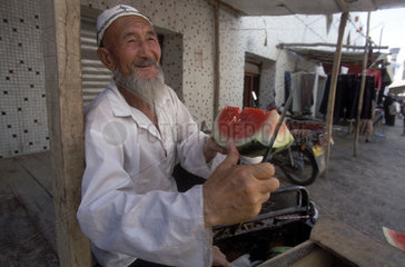 uigurischer Melonenhaendler auf einem Sonntagsmarkt