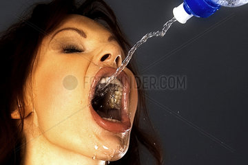 Frau laesst Wasser ueber ihr Gesicht fliessen