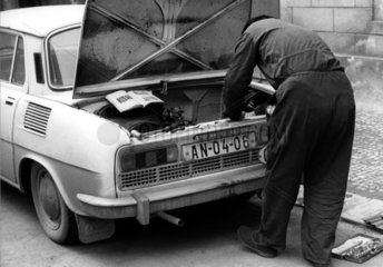 Mann repariert Auto nach Anleitung