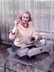 Frau posiert mit Schreibmaschine