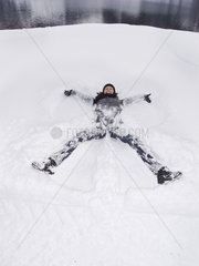Frau liegt im Schnee