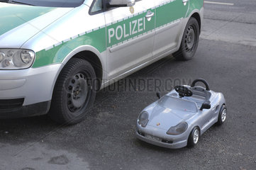 Spielzeugauto parkt neben Polizeiauto