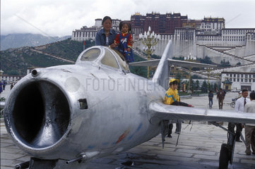 Kinder posieren auf Kampfjet vor dem Potala Palast