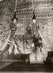 zwei Frauen und Tisch werden mit Seilen an die Decke gezogen