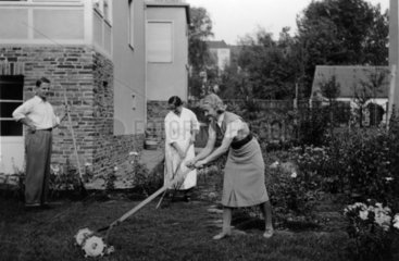 Frau maeht den Rasen