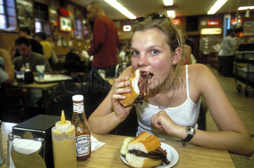 Frau isst Sandwich in einem Diner