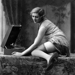 Frau posiert erotisch neben Plattenspieler