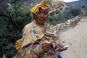 Tibet: Bettlerin mit Gebetsmuehle