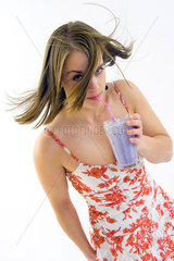 huebsche Frau trinkt verfuehrerisch einen Milchshake