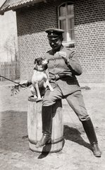 Mann in Uniform mit einem Hund sitzent