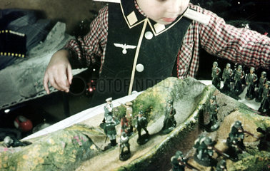 Kleiner Junge spielt mit Nazi Truppen