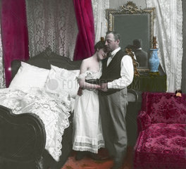 Paar umarmt sich im Schlafzimmer - Frau im Nachthemd